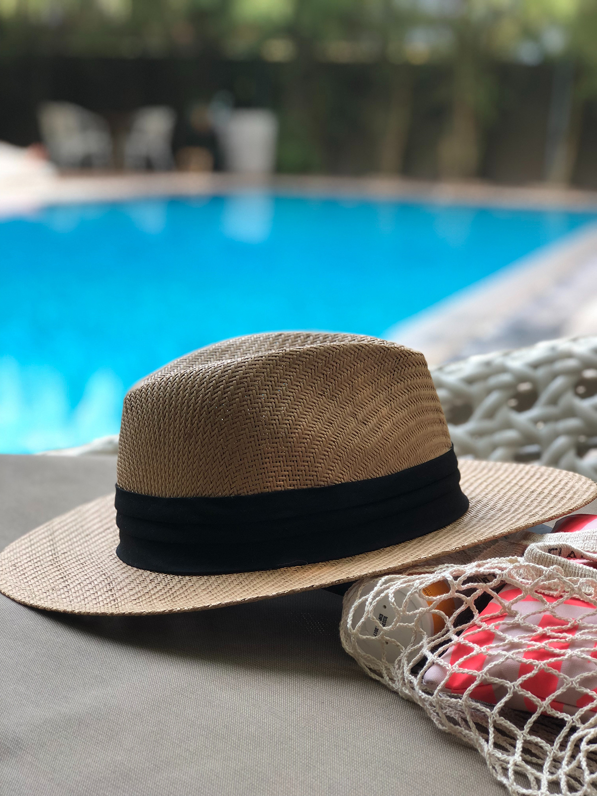 Sebuah topi di tepi kolam renang yang indah